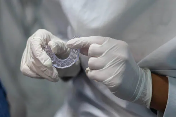 Dental technician holding night guard